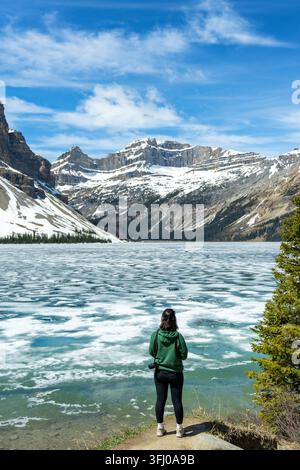 Frau genießt den gefrorenen Blick auf den Bow Lake im Banff-Nationalpark Stockfoto