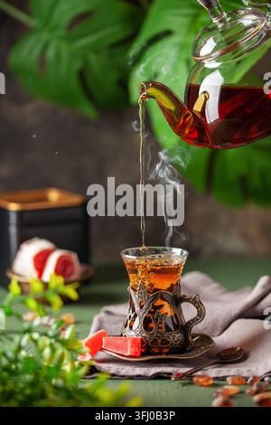Schwarzer Tee in türkischen Gläsern armudu. Östliche Teezeremonie. Stockfoto