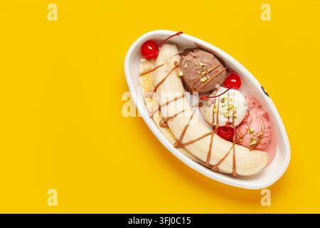 Köstliches süßes Bananensplittereis Dessert mit Karamellsirup oder Topping und Kirsche. Draufsicht/Kopierbereich Stockfoto