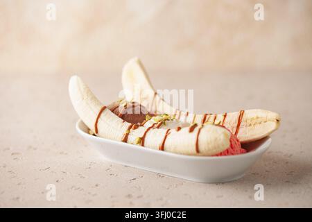 Köstliches süßes Bananensplittereis Dessert mit Karamellsirup oder Topping und Kirsche. Stockfoto