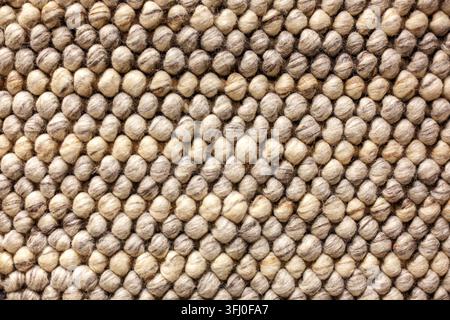 Grober Wollstrickball-Stichtextur-Makro mit beigem Sahnegarn im skandinavischen Stil Stockfoto