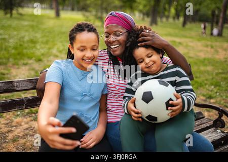 Glückliche Familie macht Selfie im Park, Mutter mit lachenden Kindern Stockfoto