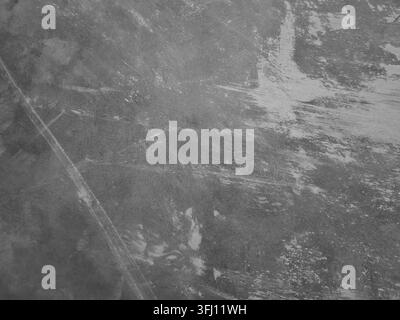 Abstrakter Vollbild-Hintergrund einer grauen Betonwand mit starken weißen Putzstrichen, feinen Kratzern und einer abgenutzten Grunge-Textur Stockfoto