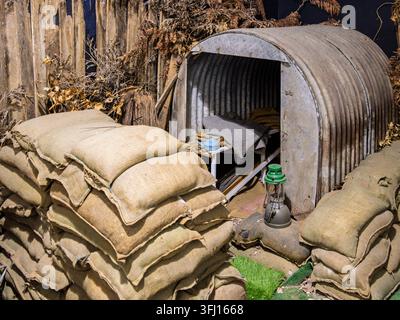 Ein Diorama-Ausstellungsstück eines Anderson-Schutzbunkers aus den 1940er Jahren mit einem wellblechverkleideten Bunker und Sandsäcken im Army Flying Museum in Hampshire, UK Stockfoto