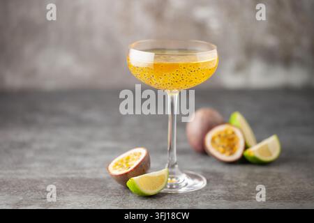 Martini-Cocktail mit Passionsfrucht. Saures alkoholisches Getränk mit frischem Passionsfrucht und Limette, mit Barwerkzeugen. Stockfoto