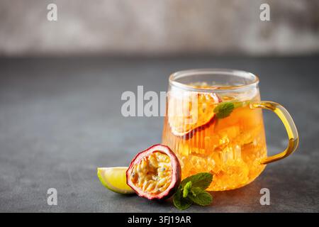 Obsteistee. Erfrischendes Sommergetränk mit Sirup, Passionsfrucht, Limette, Minze und Eis. Glas mit kaltem und gesundem Getränk Stockfoto