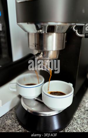 Espressomaschine brüht gleichzeitig zwei Tassen frischen heißen Kaffees Stockfoto