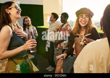 Verschiedene Gruppe von fröhlichen Freunden, die auf einer Dachparty feiern Stockfoto