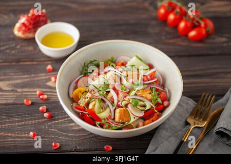 Salat mit gegrilltem Lachs, frischen grünen Blättern, Gurke, Tomaten, Pfeffer, Rettich, Granatapfel und rote Zwiebeln. Gesunder Mittagssalat Stockfoto