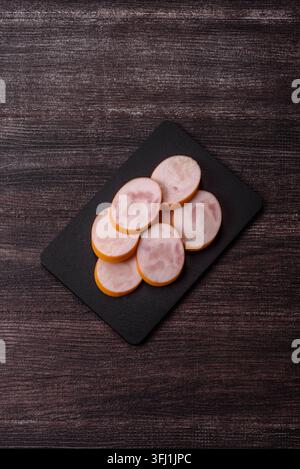 Gekochte Hähnchenwurst für Sandwiches und Antipasto zum Abendessen. Wurstscheiben als Lebensmittelhintergrund für Ihr Design Stockfoto