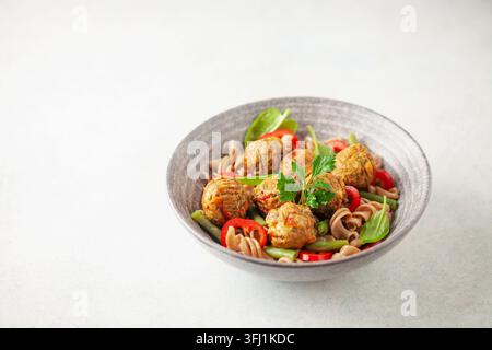 Veganes Essen. Gemüsebällchen und Buchweizennudeln mit Gemüse in einer Schüssel auf dem Tisch. Stockfoto