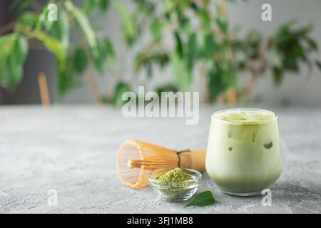 Matcha-Tee wird in Eismilch gegossen. Gesundes veganes Getränk Matcha Latte Stockfoto