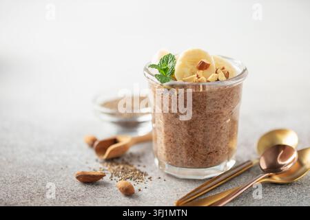 Schokoladen-Chia-Pudding aus Kokosmilch mit Mango, Heidelbeeren und Banane im Glas. Stockfoto