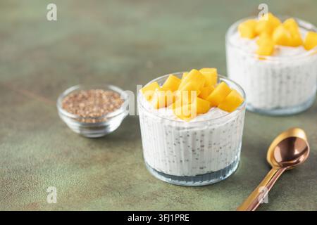Chia Samenpudding aus Kokosmilch mit Mangobaumwürfeln in einer Glasschale. Veganes Essen. Sauberes Esskonzept Stockfoto