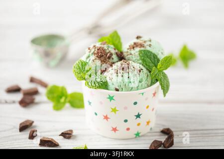 Minzschokolade-Eiskugeln in der Papierschale auf weißem Hintergrund Stockfoto