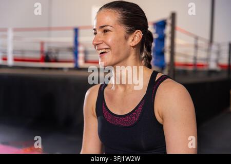 Frau mit schwarzem Tank Top magenta Sport-BH lacht und atmet beim Boxsport-Gym-Ring. Athlet, Fitness, Training, Cardio, Energie, Confidenc Stockfoto