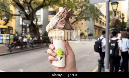 Hand, die eine zweigeschmacks-Gelato-Kegel von LemonCello Gelato im Taipa Village, Macau, China hält Stockfoto