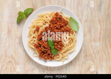Pasta Spaghetti Bolognese auf weißem Teller auf Holzunterlage. Bolognese-Sauce ist ein klassisches italienisches Gericht. Beliebte italienische Stockfoto