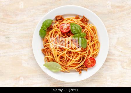 Pasta Spaghetti Bolognese auf weißem Teller auf Holzunterlage. Bolognese-Sauce ist ein klassisches italienisches Gericht. Beliebte italienische Stockfoto
