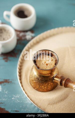 Traditioneller türkischer Kaffee in Cezve, zubereitet auf heißem Sand. Stockfoto