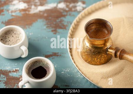 Traditioneller türkischer Kaffee in Cezve, zubereitet auf heißem Sand. Stockfoto