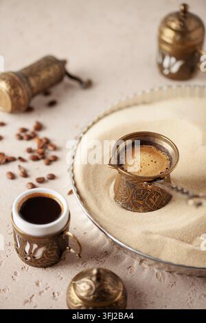 Traditioneller türkischer Kaffee in Cezve, zubereitet auf heißem Sand. Stockfoto