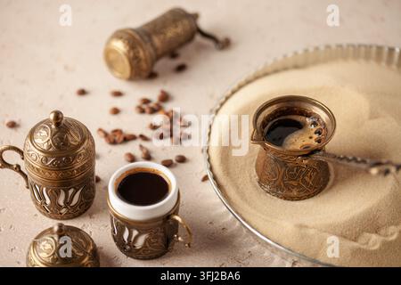 Traditioneller türkischer Kaffee in Cezve, zubereitet auf heißem Sand. Stockfoto