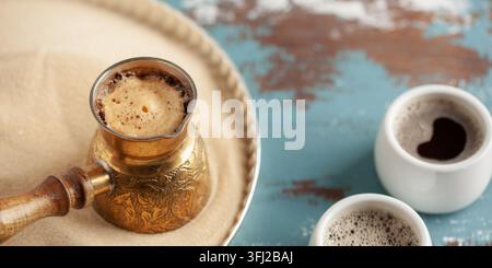 Traditioneller türkischer Kaffee in Cezve, zubereitet auf heißem Sand. Stockfoto