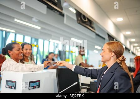 Der Check-in-Agent am Flughafen hilft Reisenden mit Bordkarte und Reisepass Stockfoto