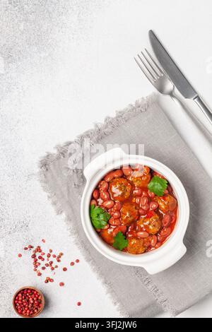 Fleisch- oder Gemüsebällchen in Tomatensauce mit Bohnen. Draufsicht. Stockfoto
