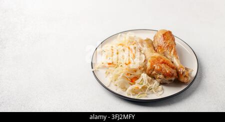 Hähnchenkeulen gegrillt mit Kohlsalat Krautsalat auf einem Teller auf dem Tisch. Gesunde Ernährung Stockfoto