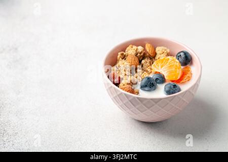 Haferflocken-Müsli mit Joghurt, Beeren, Früchten und Nüssen in einer Schüssel auf dem Tisch. Gesundes Frühstück Stockfoto