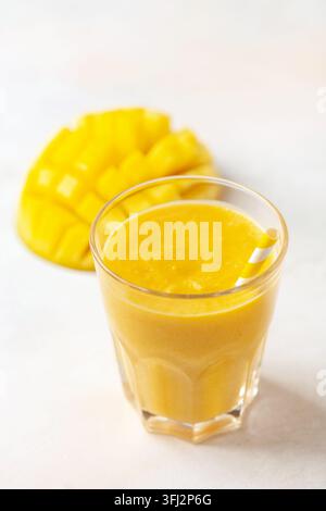 Smoothie oder Milchshake mit einer Mango in einem Glas auf dem Tisch. Diäternährung Stockfoto