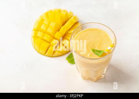 Smoothie oder Milchshake mit einer Mango in einem Glas auf dem Tisch. Diäternährung Stockfoto