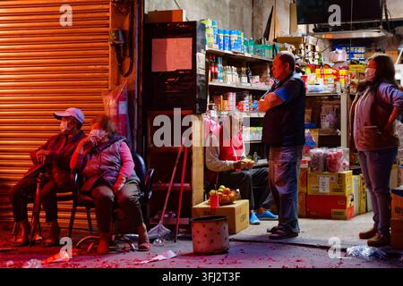 Taipei, Taiwan – 03. Mär 2026: Anwohner versammeln sich vor einem traditionellen Lebensmittelladen, der vom Licht der Feuerwerkskörper während des Laternenfestes des Erdgottes erhellt wird. Stockfoto