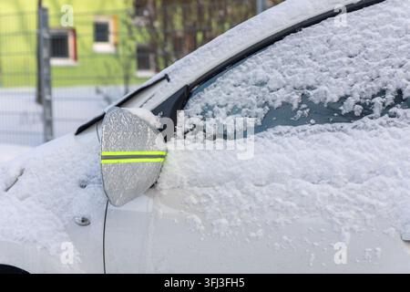 Schneebedecktes Auto verwendet reflektierende Spiegelabdeckung und Windschutzscheibenprotektor, um Frost- und Eisbildung im Winter zu verhindern. Schutzzubehör hilft Stockfoto