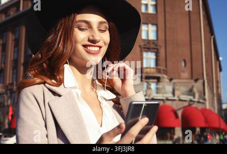 Glückliche Frau geht an einem Herbsttag in der Stadt spazieren Stockfoto