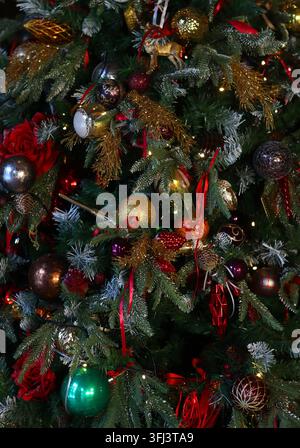 Neujahrs- oder Weihnachtsinterieur zu Hause. Stilvoller Weihnachtsbaum mit roten und goldenen Dekorationen. Feiertagskonzept. Stockfoto