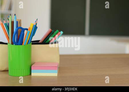 Schreibwaren auf einem Holzschreibtisch im Klassenzimmer, Nahaufnahme. Platz für Text Stockfoto
