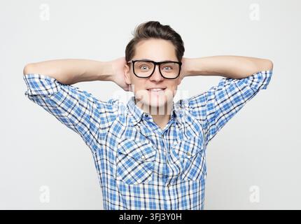 Porträt eines jungen Mannes in lässiger Kleidung, der gegen einen weißen Hintergrund steht Stockfoto