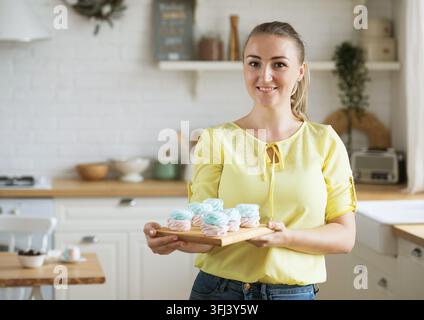 Junge Bäckerin mit Gebäck. Glücklich, lächelnd und fröhlich. Freelance, Essen und Hobbykonzept. Stockfoto