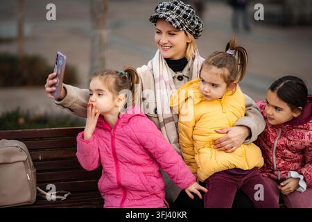 Mutter und drei Kinder machen Selfie im Freien im Winter Stockfoto