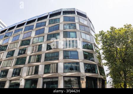 Gekrümmte Glas- und Stahlfassade eines modernen Gewerbegebäudes in der Stadt Stockfoto