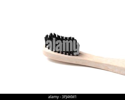Nahaufnahme einer Bambus-Zahnbürste mit schwarzen Borsten, isoliert auf Weiß Stockfoto