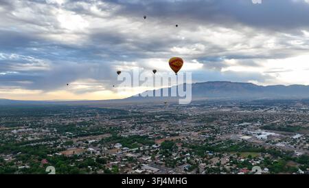Albuquerque, New Mexico, Heißluftballonfestival. Luftaufnahme von vielen Heißluftballons, die hoch über dem malerischen Albuquerque fliegen, mit Blick auf die Stadt und die Berge Stockfoto