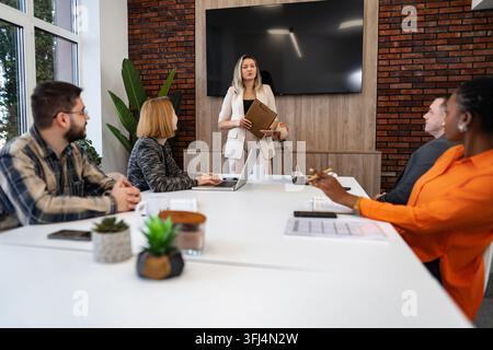 Geschäftsfrau führt ein Meeting mit einem diversen Team in einem modernen Büro Stockfoto