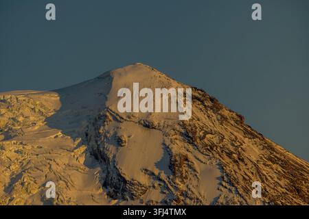 Nahaufnahme des schneebedeckten Gipfels des Mount Adams, der vom späten Tageslicht in der Kaskadenkette im Bundesstaat Washington, USA, beleuchtet wird. Stockfoto
