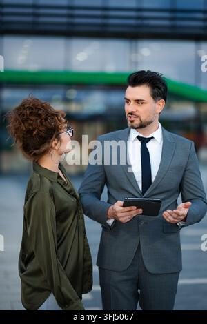 Geschäftskollegen führen eine Diskussion mit einem Tablet im Freien Stockfoto