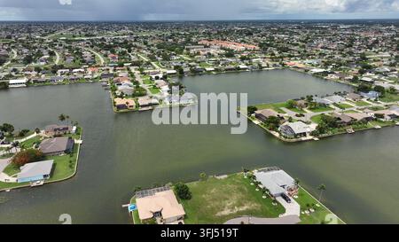 Luftaufnahme einer Luxusvilla und eines Herrenhauses auf einer Insel in Cape Coral, Florida an einem sonnigen Tag. Edle Palmen auf dem Grundstück. Breitwinkelaufnahme. Stockfoto