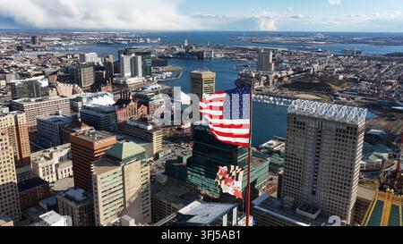 Luftbild der Innenstadt von Baltimore mit dem Inner Harbor, Hochhaus-Skyline, Uferpromenade und großer amerikanischer Flagge, die an einem klaren Sonnentag über der Stadt weht Stockfoto